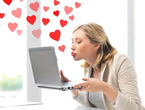 Woman sending kisses with laptop computer