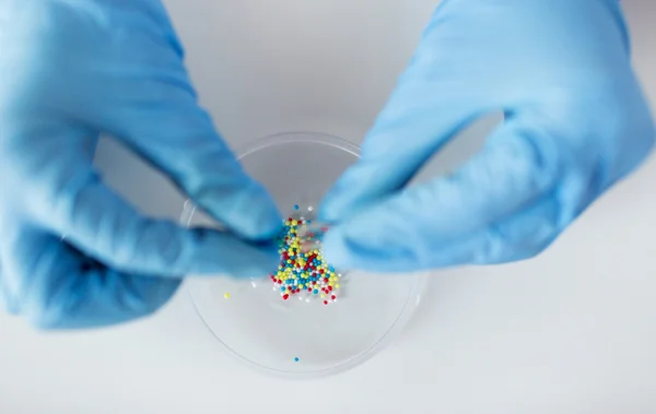 Close up of scientist hands holding pill in lab