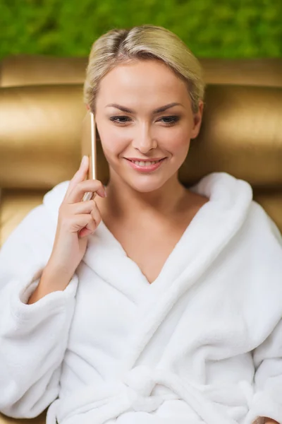 Beautiful young woman with smartphone at spa