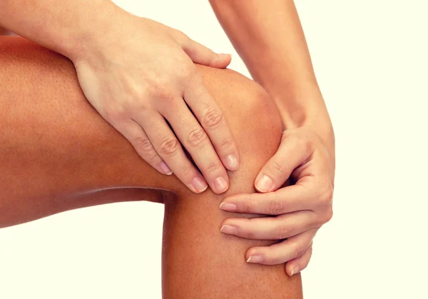 Close up of female hands holding knee