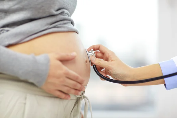 Pregnant woman belly and doctor