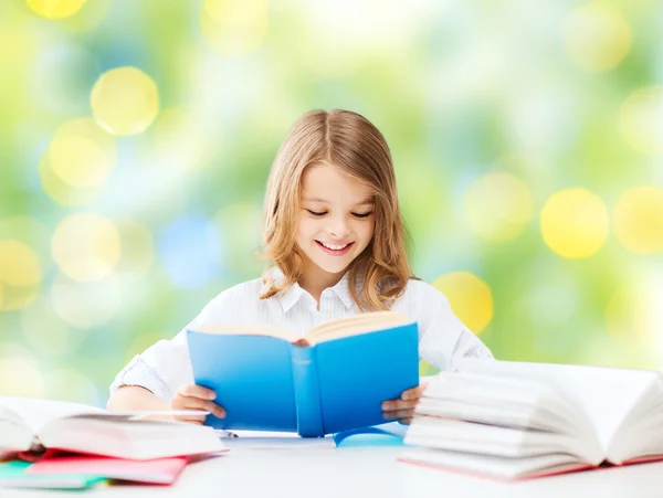 Happy student girl reading book at school