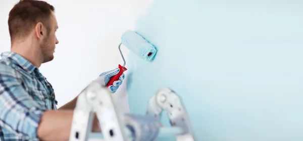 Close up of male in gloves holding painting roller