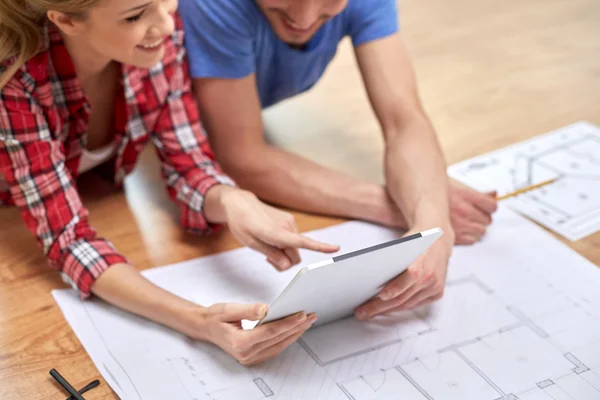 Close up of couple with tablet pc and blueprint