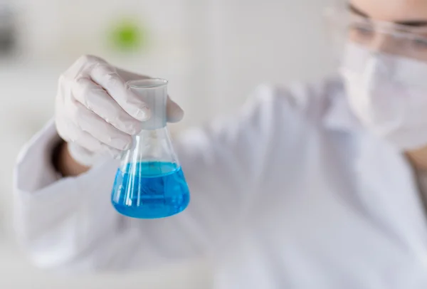 Close up of woman with flask making test in lab