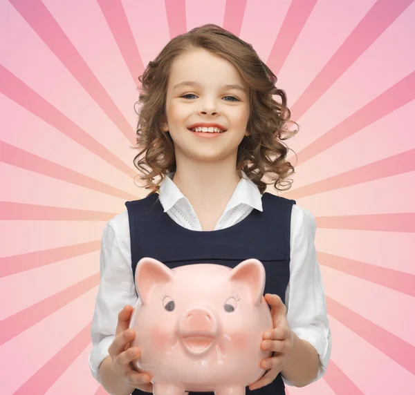 Happy girl holding piggy bank