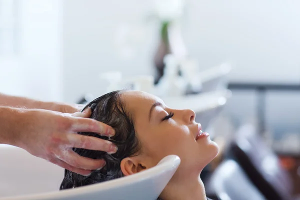 Happy young woman at hair salon