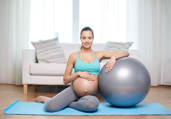Happy pregnant woman with fitball at home