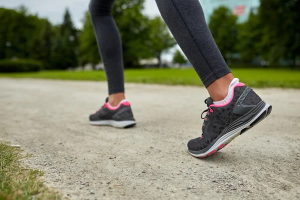 Close up of woman feet running on track from back