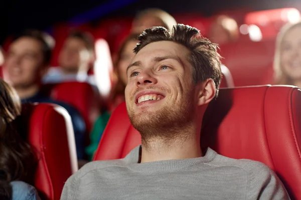 Happy young man watching movie in theater