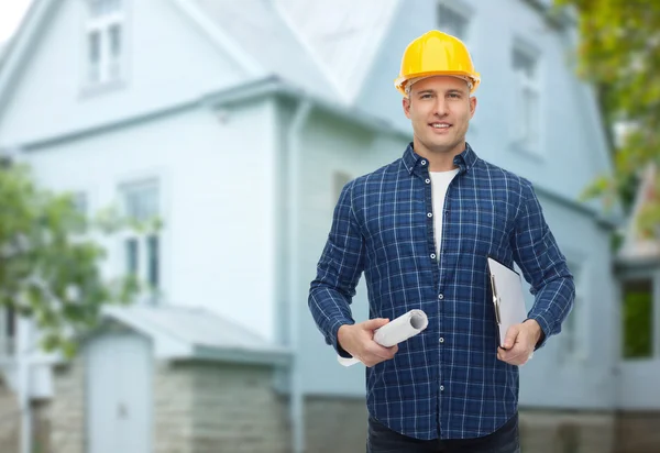 Smiling male builder in helmet with blueprint