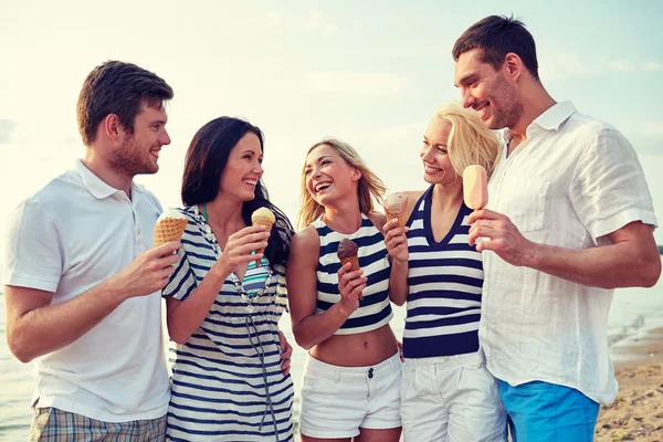 Friends eating ice cream and talking on beach