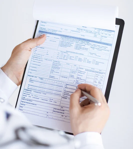 Male doctor holding prescription paper in hand