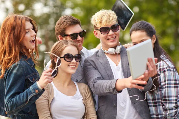 Students or teenagers with tablet pc taking selfie
