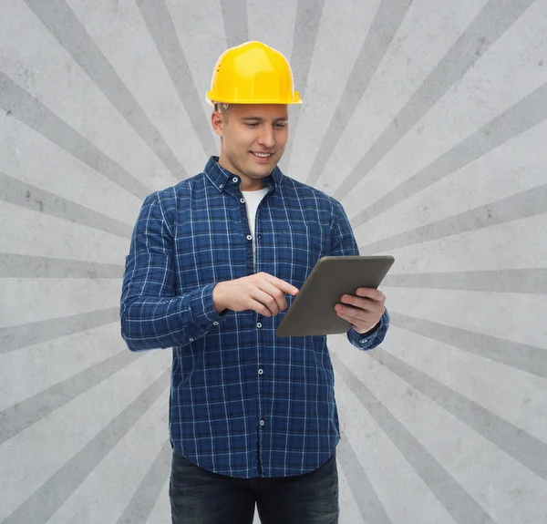 Smiling male builder in helmet with tablet pc