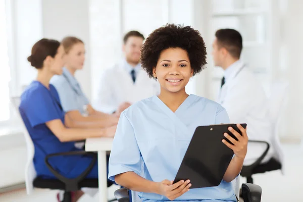 Happy doctor over group of medics at hospital