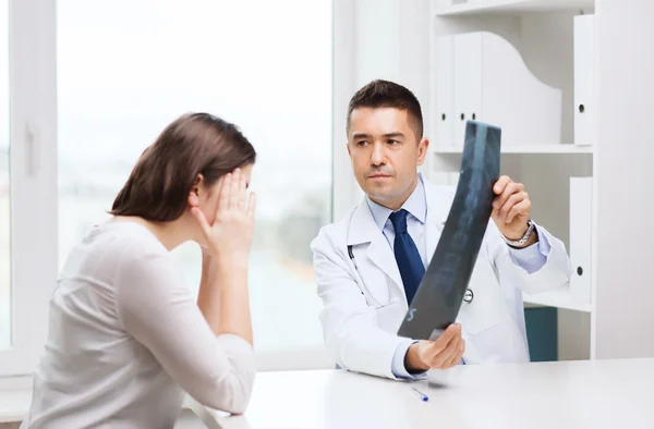 Smiling male doctor in white coat looking at x-ray