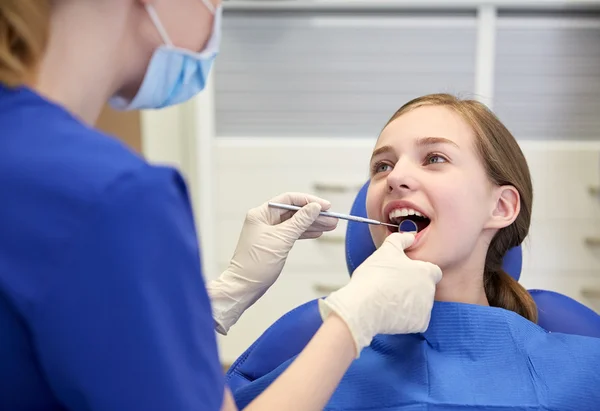 Female dentist checking patient girl teeth