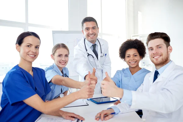 Group of doctors showing thumbs up at hospital