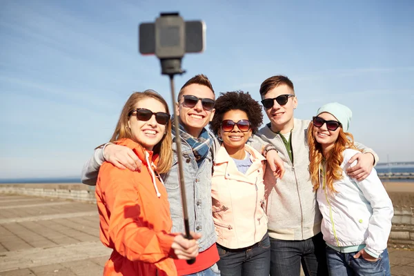 Smiling friends taking selfie with smartphone
