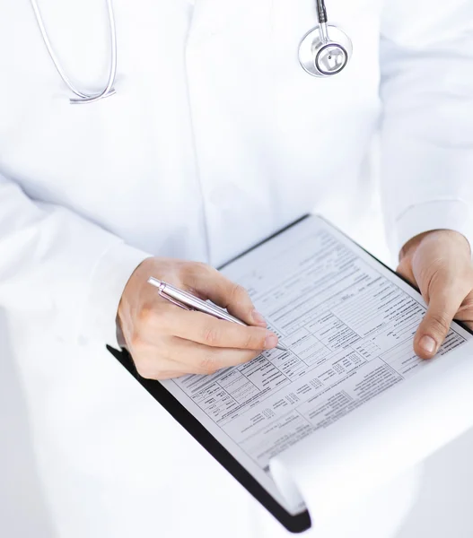 Male doctor holding prescription paper in hand