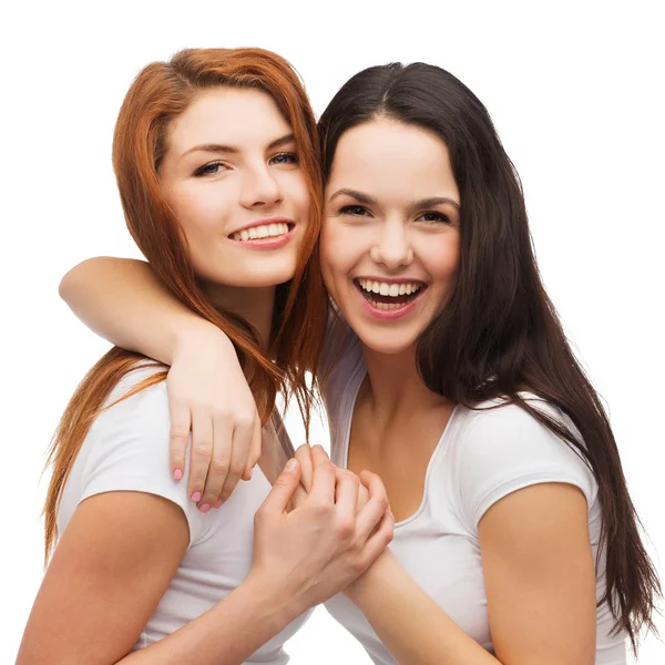 Two laughing girls in white t-shirts hugging