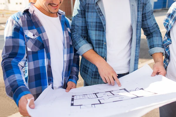 Close up of smiling builders with blueprint