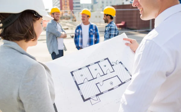 Close up of architects with blueprint at building