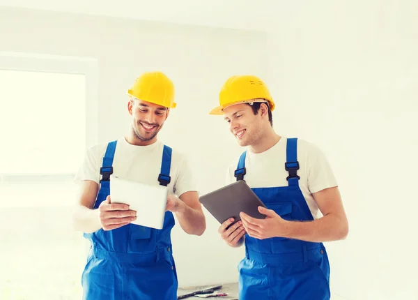 Builders with tablet pc and equipment indoors