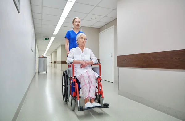 Nurse with senior woman in wheelchair at hospital