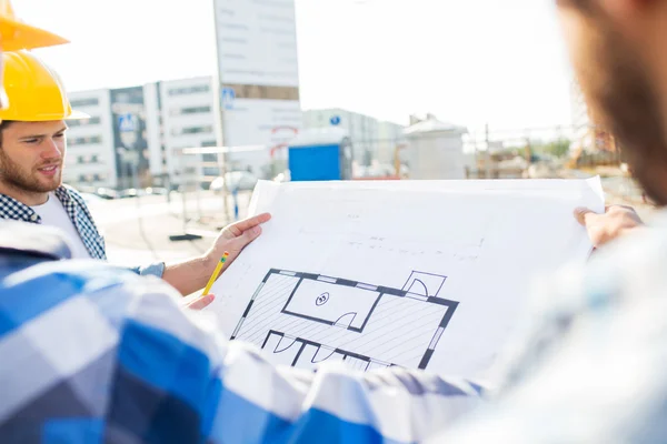 Close up of builders with blueprint at building