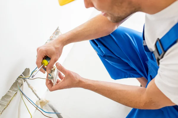 Close up of hands with screwdriver fixing socket