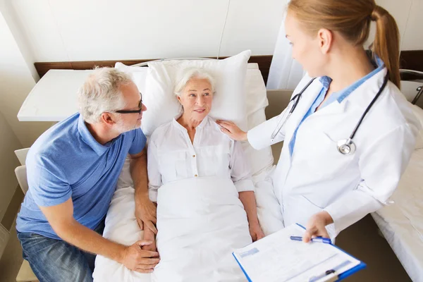 Senior woman and doctor with clipboard at hospital