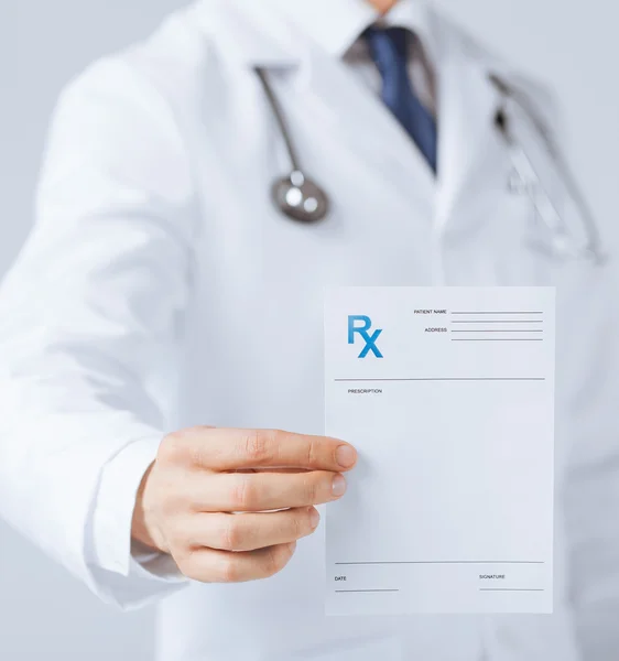 Male doctor holding rx paper in hand