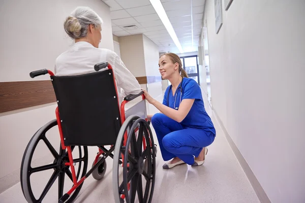 Nurse with senior woman in wheelchair at hospital