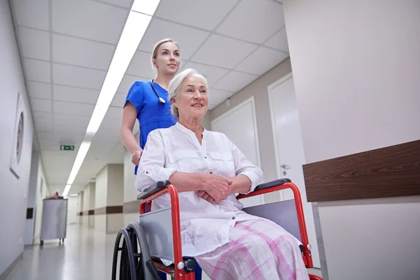 Nurse with senior woman in wheelchair at hospital