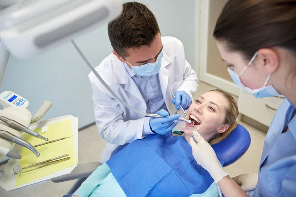 Dentist treating female patient teeth