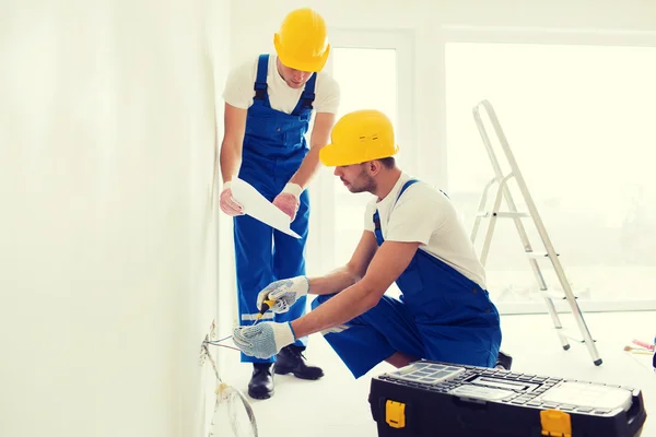 Builders with tablet pc and equipment indoors