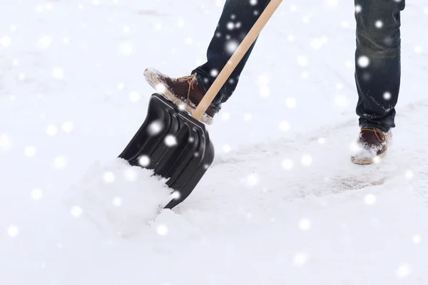 Closeup of man digging snow with shovel