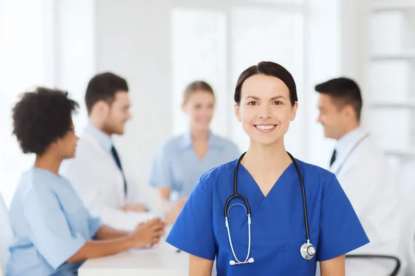 Happy doctor over group of medics at hospital