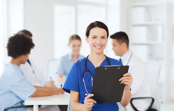 Happy doctor over group of medics at hospital