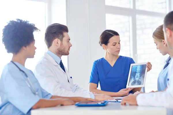 Group of doctors with x-ray on tablet pc at clinic