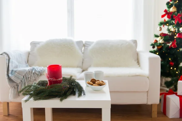 Sofa, table and christmas tree with gifts at home