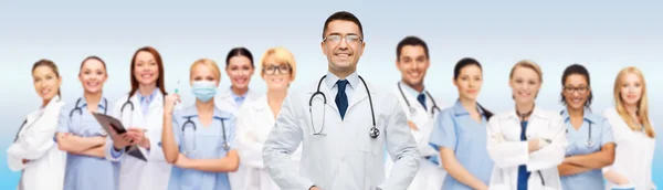 Group of smiling doctors with clipboard over gray