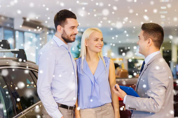 Happy couple with car dealer in auto show or salon