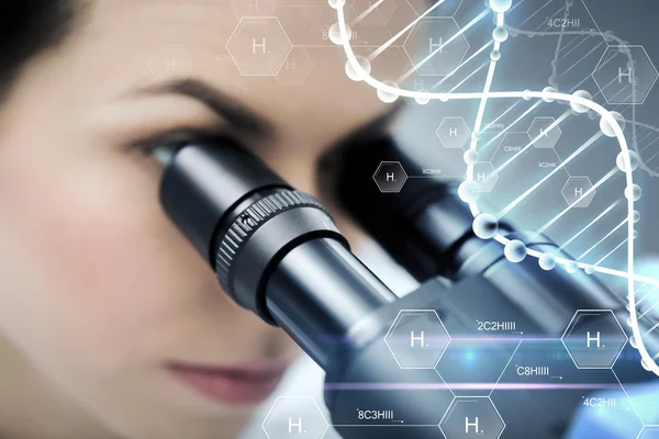 Close up of scientist looking to microscope in lab