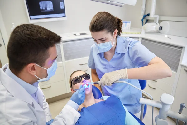 Dentists treating male patient teeth at clinic
