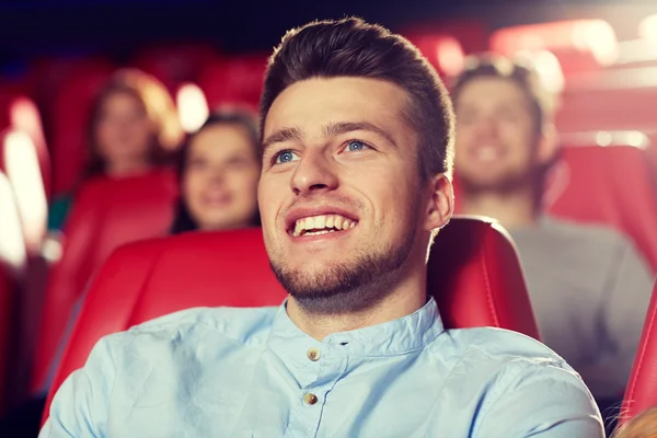 Happy young man watching movie in theater
