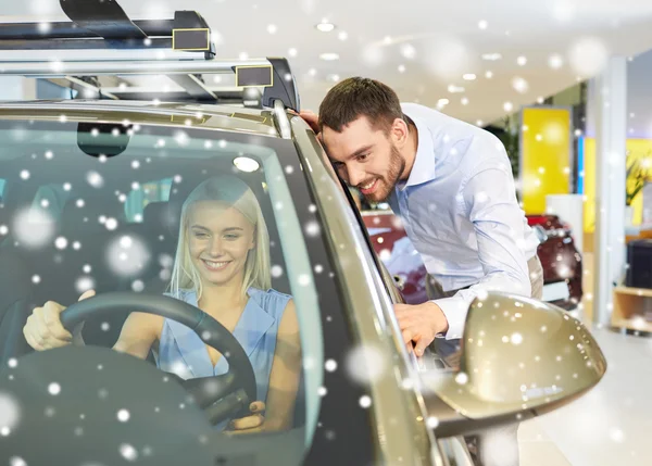 Happy couple buying car in auto show or salon