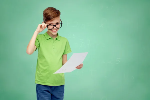 Happy boy in eyeglasses holding school test result